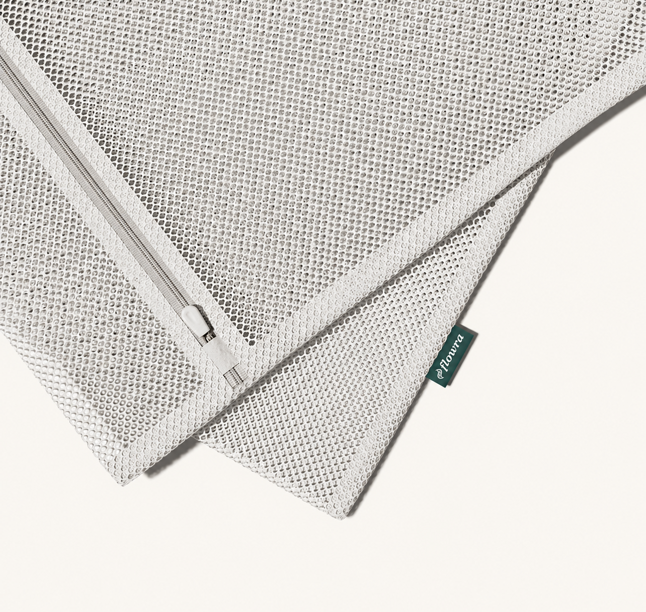 Flowra Premium Wash Bag — close-up detail of the mesh fabric, zipper, and Flowra logo tag