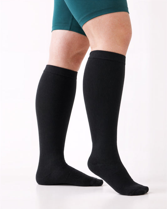 Wide Calf compression sock in Classic Black, full knee-high coverage, standing pose